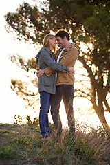 Image showing Outdoor, hug and couple with love, nature and happiness with romance and bonding together in a park. People, embrace or woman with man or date with marriage or relationship with sunset or anniversary