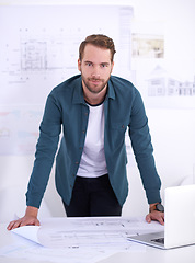 Image showing Portrait, laptop and blueprint with architect man in office with documents for building, design or planning. Architecture, construction and industry with confident young developer in workplace