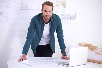 Image showing Portrait, laptop and layout with architect man in office with documents for building, construction or design. Architecture, construction and blueprint with confident young developer in workplace