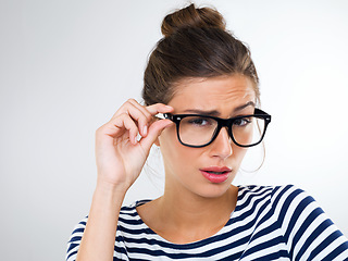 Image showing Confused, woman and portrait with surprise in studio, white background and mockup of questions. Doubt, why and college student with glasses thinking of feedback or information with anxiety or stress