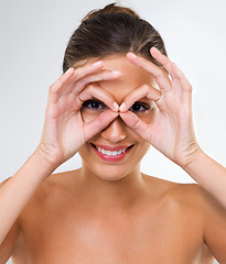 Image showing Happy woman, portrait and beauty with makeup, cosmetics or skincare on a gray studio background. Face of attractive female person, brunette or model with smile and hands on face for facial treatment