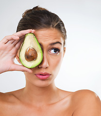 Image showing Woman, face and avocado for health in studio for wellness detox, healthy skin and hydration with omega 3. Model, person and fruit for organic cosmetics, natural beauty or skincare on white background