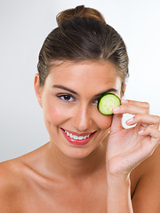 Image showing Woman, portrait and cucumber for health in studio with wellness detox, healthy eating and nutrition diet. Model, person and fruit for organic cosmetics, natural beauty or skincare on white background