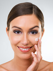 Image showing Woman, portrait and cream for skincare with beauty, dermatology with cosmetics product or moisturizer in studio. Face, sunscreen or lotion for skin glow and antiaging facial on white background