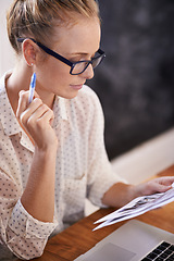 Image showing Paperwork, designer and woman with remote work, laptop or pictures in home office for creative research. Reading, documents review or freelancer in a startup or business in her house with photograph