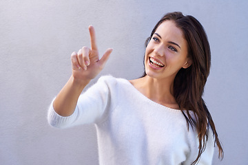 Image showing Fashion, pointing and woman with smile for sweater with warm, texture and casual for winter. Studio background, female person with happiness, joy and girl with jersey of wool for comfort in New York