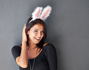 Image showing Bunny ears, space or portrait of happy woman with fashion or style isolated on grey background. Model laughing, confident or casual female person in studio with smile, easter holiday or mock up