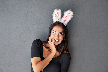 Image showing Thinking, space or portrait of happy woman with bunny ears isolated on wall or grey background. Model laughing, confident or casual female person in studio with smile, funny joke or ideas on mock up