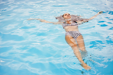 Image showing Bikini, swimming and woman in pool on holiday, vacation and travel to relax, calm and cool in summer. Female person, gen z girl and young lady floating with water, mockup space and outdoor in Spain