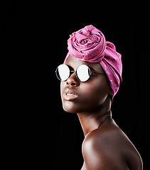 Image showing Face, fashion and shades with African woman in studio isolated on black background for heritage. Beauty, model and sunglasses with confident young person in trendy headwear for traditional style