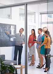 Image showing Creative man, chalkboard and coaching with team for storyboard, development or meeting at office. Speaker talking to group of employees for project planning, production or presentation in startup