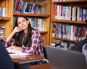 Image showing University student, thinking or studying in library for test or scholarship on campus for class assignment. Young, woman and happy for education learning and books for exam preparation by desk