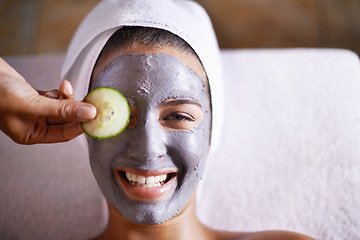 Image showing Woman, smile and facial in spa for skincare, clay mask and cosmetic treatment for break or peace. Young person with cucumber on eye and product for peel for natural or holistic therapy for wellness