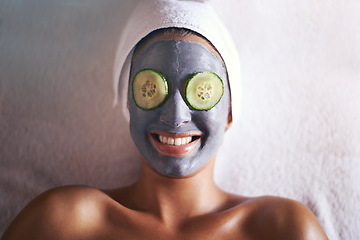 Image showing Woman, face mask and smile with skin glow and cucumber for facial, spa wellness and beauty treatment. Above, towel and calm female person with skincare and relax at hotel with cosmetic cream