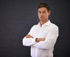 Image showing Businessman, portrait and professional with confidence for career or startup on a dark studio background. Serious man or handsome employee and arms crossed in leadership or management on mockup space