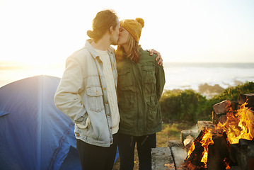 Image showing Camping, fire and kissing with couple on beach together for holiday, romance or vacation in summer. Nature, sunset or tent with young man and woman hugging at coast by ocean or sea for adventure