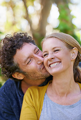 Image showing Happy, couple and kiss outdoor for love and bonding, trust and support in commitment for marriage. Partner, loyalty and joy with people in nature for fresh air, date and affection in relationship