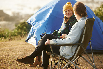 Image showing Conversation, camping and couple by tent on vacation, adventure or holiday in woods. Smile, love and young man and woman talking, bonding and relaxing in outdoor forest for weekend trip in nature.