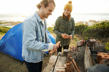 Image showing Nature, happy and couple with fire for camping on romantic vacation, adventure or holiday. Smile, love and young man and woman with flame for warm on outdoor winter weekend trip with tent together.