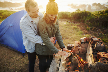 Image showing Nature, sunset and couple with fire for camping on romantic vacation, adventure or holiday. Happy, love and young man and woman with flame for warm on winter weekend trip with tent together.