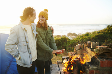 Image showing Nature, love and couple with fire for camping on romantic vacation, adventure or holiday. Happy, smile and young man and woman with flame for warm on outdoor winter weekend trip with tent together.