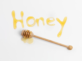 Image showing Honey, wood and product in studio in isolated white background for medicine, nutrition or wellness with text. Sweet, top view and stick for produce, organic food and healthy ingredients by writing