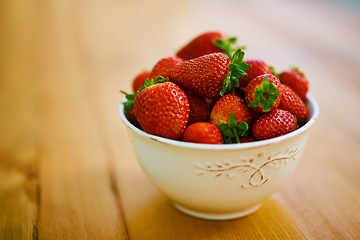 Image showing Food, health and strawberry bowl in kitchen of home, on wooden counter top for diet or nutrition. Fruit, wellness and lose weight with berries on surface in apartment for detox, minerals or vitamins