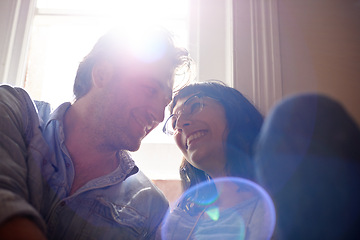 Image showing Lens flare, relax or happy couple laughing in home living room in conversation and speaking together. Man, funny woman or romantic people in apartment or house talking with love, low angle or joke