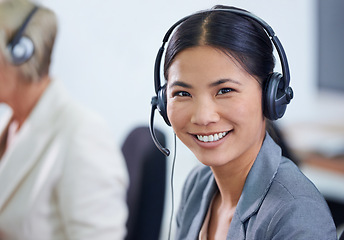 Image showing Help desk, portrait and phone call with Asian woman, headset and consultant at customer support office. Mic, telemarketing and client service agent at callcenter with happy, friendly face and smile