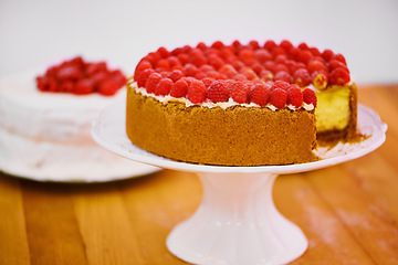 Image showing Stand, slice and cheesecake with cream and raspberries on table for sweet snack for tea time at home. Bakery, catering and gourmet dessert with crust, frosting and fresh organic fruit in dining room.