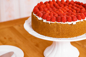 Image showing Stand, cream and cheesecake with raspberries on table for sweet snack for tea time at home. Bakery, catering and closeup of gourmet dessert with crust, frosting and fresh organic fruit in dining room