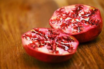 Image showing Food, fruit and pomegranate on wooden table in kitchen for diet, health or nutrition closeup. Wellness, minerals and vitamins with healthy produce on counter or surface in apartment for detox