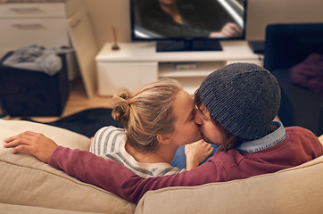 Image showing Love, kiss and couple watching tv on a sofa with romance, fun or bonding at home together. Television, movies or people embrace in a living room with trust, support or film, video or Netflix in house