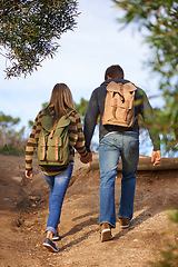 Image showing Path, hiking and couple holding hands in nature for holiday, travel or adventure outdoor with backpack. Rear view, man and woman trekking in the countryside on vacation, journey and date together
