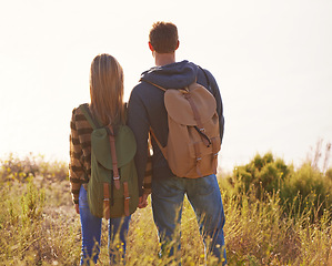 Image showing Hiking, couple and holding hands in nature for holiday, travel or adventure outdoor with backpack. Rear view, man and woman trekking in the countryside on vacation, journey or date together on mockup