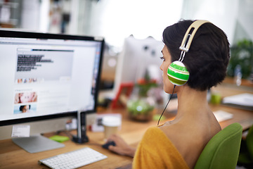 Image showing Business, designer and woman with headphones at computer screen in office for creative internship and web design. Employee, rear view and monitor for multimedia production and video animation at desk