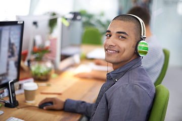 Image showing Business, designer and portrait of man with headphones in office on computer for creative internship and web design. Employee, face and happiness for multimedia production, website or video at desk