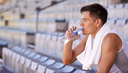 Image showing Stadium, relax man or athlete for drinking water and commitment to fitness for sprinting competition. Person, competitive and runner with thinking in sport, planning and health drink for performance