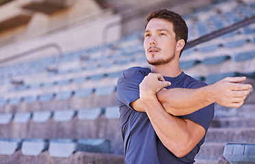 Image showing Sports, arms and man stretching in stadium for race, marathon or competition training for health. Fitness, energy and male runner athlete with warm up exercise for running cardio workout on track.