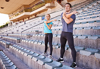 Image showing Fitness, arms and couple stretching at stadium for race, marathon or competition training for health. Sports, energy and runner athletes with warm up exercise for running cardio workout on track.