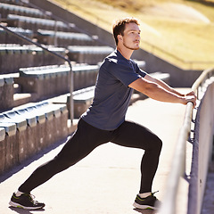 Image showing Sports, legs and man stretching at stadium for race, marathon or competition training for health. Fitness, wellness and male runner athlete with warm up exercise for running cardio workout on track.