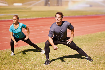 Image showing Sports, legs and people stretching at stadium for race, marathon or competition training for health. Fitness, energy and couple athletes with warm up exercise for running cardio workout on track.