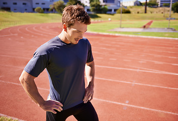 Image showing Fitness, thinking and man on running track for competition training, race and performance. Workout, power and runner at stadium for exercise, warm up and sports athlete at start for sprint challenge
