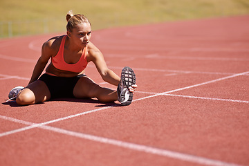 Image showing Exercise, legs and woman stretching in stadium for race, marathon or competition training for health. Sports, runner and female athlete with warm up for fitness running cardio workout on track.
