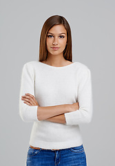 Image showing Portrait, arms crossed and woman in studio for fashion isolated on a white background. Confidence, young person and serious model in casual clothes, jeans or trendy style on backdrop in Argentina
