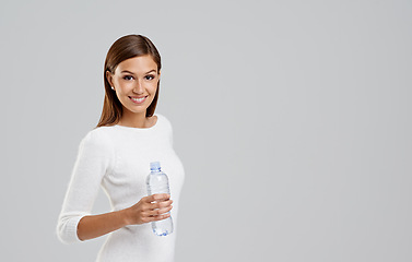 Image showing Portrait, happy woman and drinking water in studio isolated on a white background mockup space for wellness. Face, bottle and person with liquid for hydration, nutrition and healthy diet for body