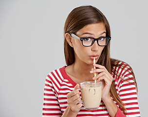 Image showing Woman, portrait and iced coffee drinking in studio or sweet beverage for weekend relax, caffeine or grey background. Female person, glasses and dairy for latte smoothie, mockup space or happiness