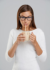 Image showing Studio, woman and glasses with coffee, drink and ice for relax and rest. Model, beverage and straw with glass mug, portrait and face for break or nutrition with milkshake isolated on white background