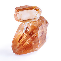 Image showing Gem, crystal and orange stone in studio with isolated white background for natural resource, shine and sparkle for luxury. Rock, jewel and reflection in closeup for citrine, glow and mineral