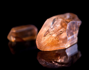 Image showing Orange stone, jewel and crystal in studio with isolated black background for natural resource, shine and sparkle for luxury. gemstone, rock and reflection in closeup for citrine, glow and mineral